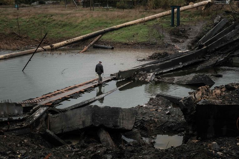 A man crosses a damaged bridge in Bashmoet.  AFP photo